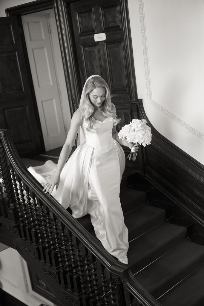 Bride walking down stairs holding flowers