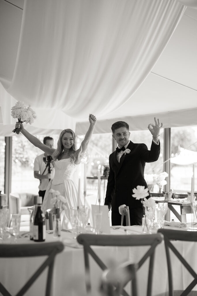 Wedding couple stood at dinner table celebrating